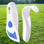 Palmilha esportiva ortopedica X branca, para pés chatos, planos, pisada pronada, com detalhes azuis dobrada demonstrando flexibilidade e maleabilidade do material em ambiente externo com gramado Universo Vigor Saúde