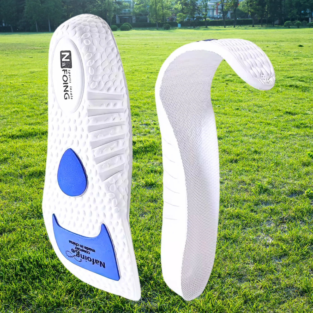 Palmilha esportiva ortopedica X branca, para pés chatos, planos, pisada pronada, com detalhes azuis dobrada demonstrando flexibilidade e maleabilidade do material em ambiente externo com gramado Universo Vigor Saúde