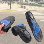Composição de três ângulos da palmilha ortopédica X preta, para pés chatos, planos, pisada pronada, com fundo desfocado de faixa de pedestres na rua, exibindo uma unidade estendida mostrando o solado texturizado em esferas com amortecedores azuis, uma unidade enrolada e uma mão flexionando a base de gel