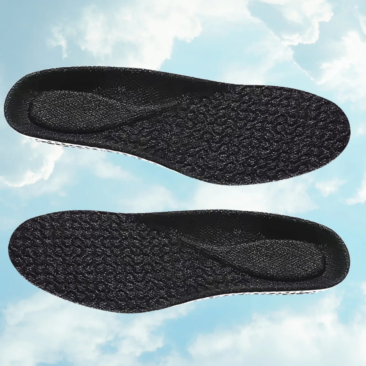 Apresentação dupla horizontal de um par de palmilhas ortopédicas X pretas, para pés chatos, planos, pisada pronada, flutuando contra fundo de céu azul claro com nuvens, destacando a textura antiderrapante da malha superior e o formato anatômico simétrico