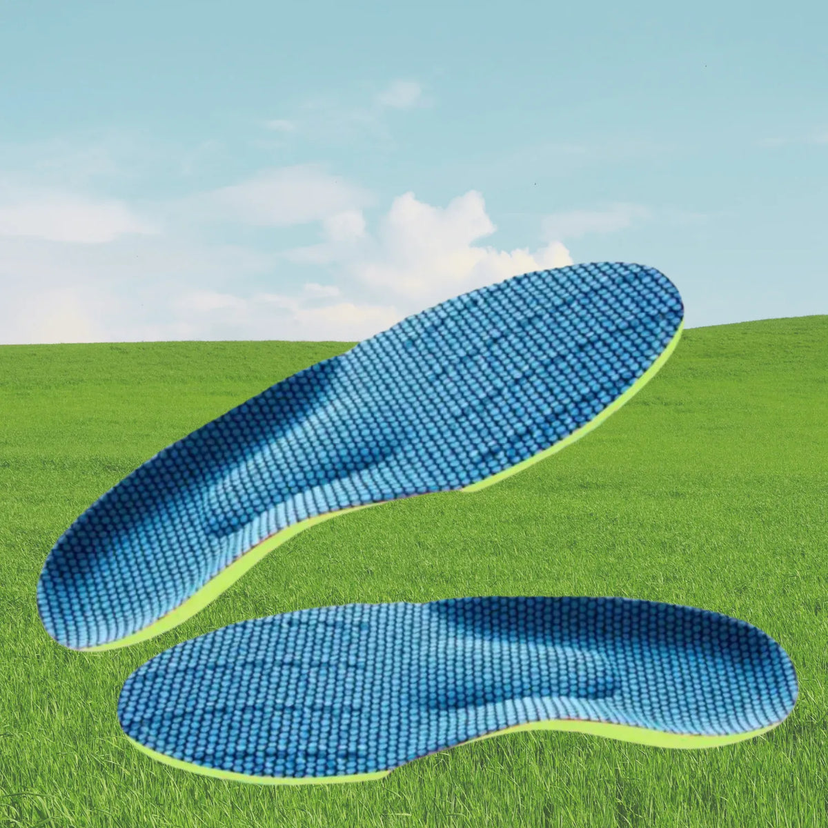 Par de palmilhas ortopédicas X ergonômicas, para pés chatos, planos, pisada pronada, na cor verde-limão com revestimento de malha azul texturizada, disposto sobreposto em um cenário de gramado verde e céu ensolarado ao fundo